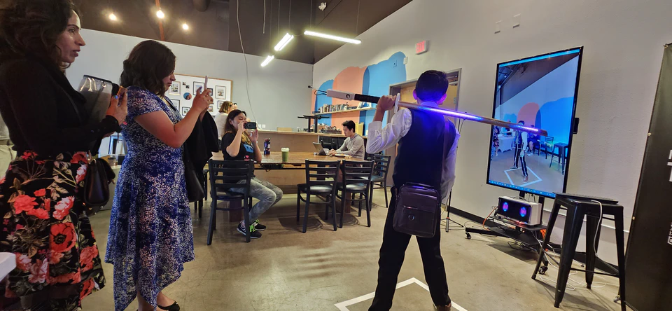 Visitors watching the bokken and body-tracking demonstration inside Moongoat Coffee.