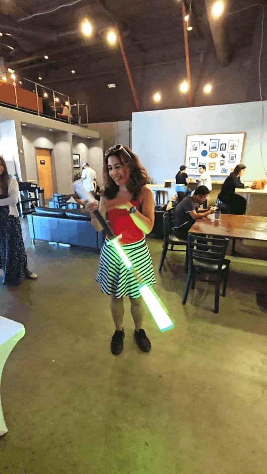 A visitor spinning a bokken at PixelPerf Market as its lights change color.